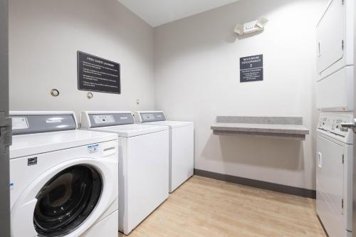 a white laundry room with a washer and dryer at Candlewood Suites Houston Westchase - Westheimer by IHG in Houston