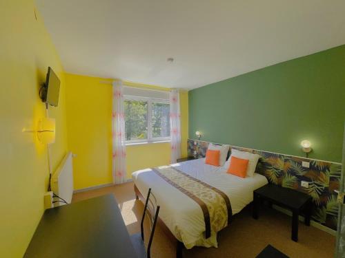 een slaapkamer met een bed en een groene muur bij Hotel Le Ronchamp in Ronchamp