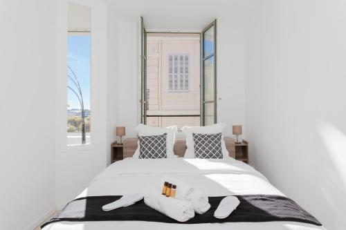 Un dormitorio con una cama blanca con dos almohadas. en Anzur YourHostHelper, en Cannes