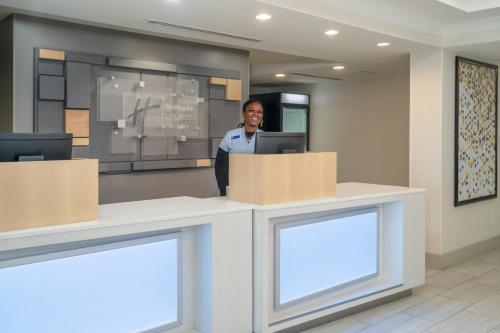 a man standing behind a counter in a lobby at Holiday Inn Express Hotel & Suites Bluffton at Hilton Head Area by IHG in Bluffton