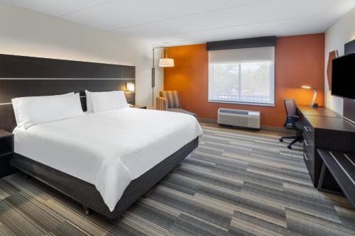 a hotel room with a bed and a flat screen tv at Holiday Inn Express Hotel & Suites Bluffton at Hilton Head Area by IHG in Bluffton