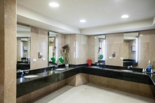 a large bathroom with two sinks and mirrors at Lidotel Caracas in Caracas