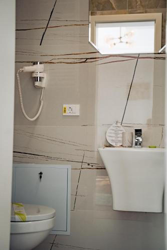 a bathroom with a toilet and a sink at Hotel B4 in Oradea