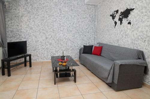 uma sala de estar com um sofá e uma mesa em Sunrise Apartment em Heraclião