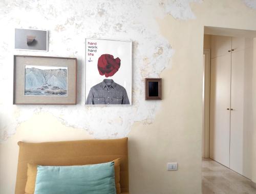 a bedroom with a bed and a wall with paintings at Noù la tua casa in Puglia in Alberobello