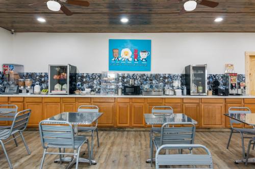 a restaurant with tables and chairs and a counter at Rodeway Inn Broken Bow-Hochatown in Broken Bow