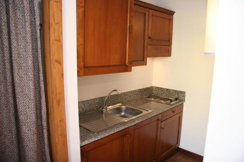 a kitchen with a sink and wooden cabinets at Stintino Country Paradise - Resort & Villas in Stintino