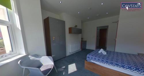 a bedroom with a bed and a chair and a window at Victoria House - Deluxe Studios in Coventry City Centre, free parking, by COVSTAYS in Coventry