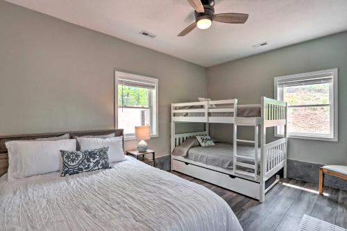 a bedroom with two bunk beds and a ceiling fan at Grill and Fire Pit Blue Cabin Ozarks Getaway! in Camdenton