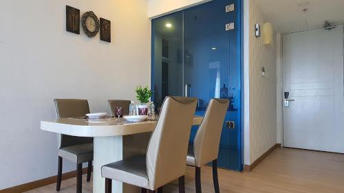a dining room with a white table and chairs at The Wave Suites Melaka in Melaka