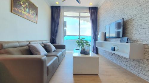 a living room with a couch and a tv at The Wave Suites Melaka in Melaka