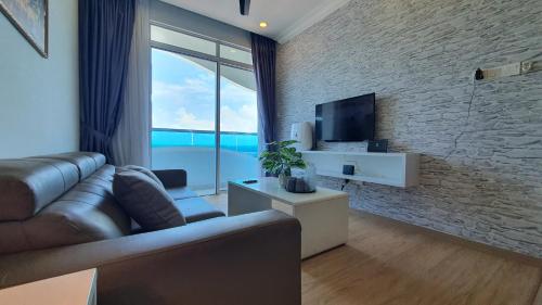 a living room with a couch and a television at The Wave Suites Melaka in Melaka