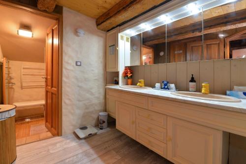 a bathroom with two sinks and a large mirror at Gîte de la Chapelle des Mineurs in Sainte-Marie-aux-Mines