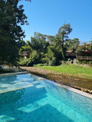 a swimming pool with blue water in a yard at In Hospedagem in Paraty