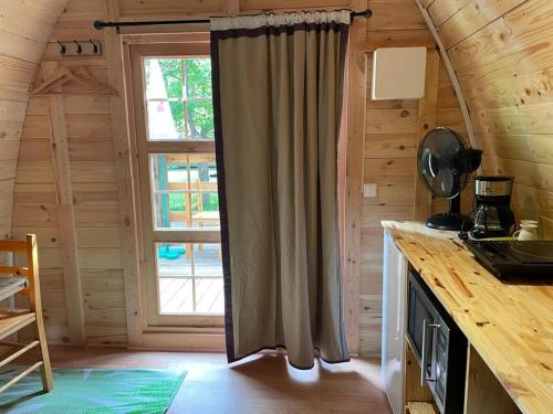 a kitchen with a window in a log cabin at Camping du lac in Saint-Julien-du-Verdon