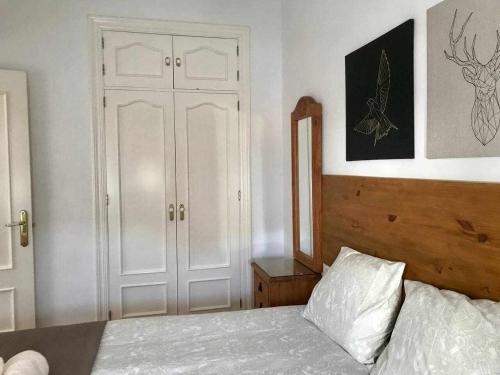 1 dormitorio con cama blanca y puerta blanca en Acogedor apartamento en Málaga centro, en Málaga