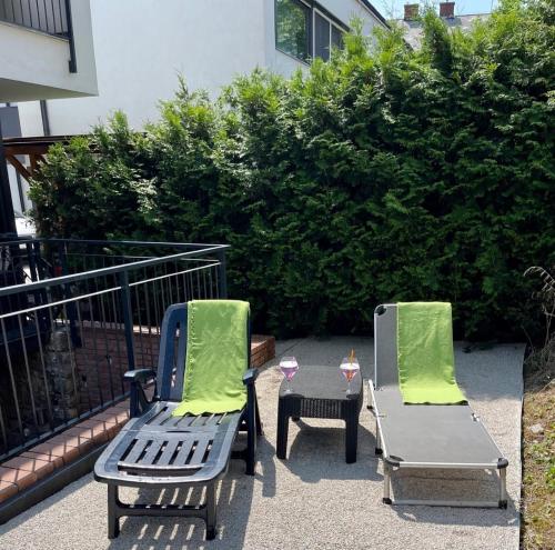 twee stoelen en een tafel met een drankje op een patio bij Emifüred in Balatonfüred