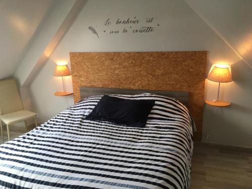 une chambre avec un lit avec un panneau sur le mur dans l'établissement Maison chaleureuse toute équipée pour vos vacances, à Saint-Quay-Portrieux