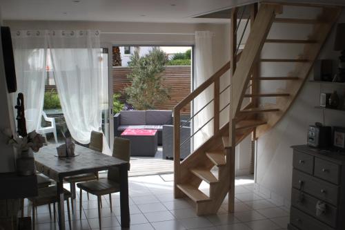 - un escalier dans le salon avec une table et des chaises dans l'établissement Maison chaleureuse toute équipée pour vos vacances, à Saint-Quay-Portrieux