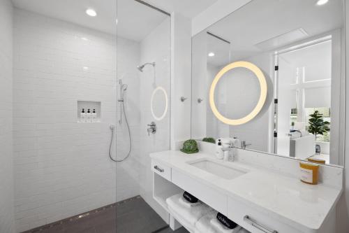 a white bathroom with a sink and a mirror at The Iris in Charleston