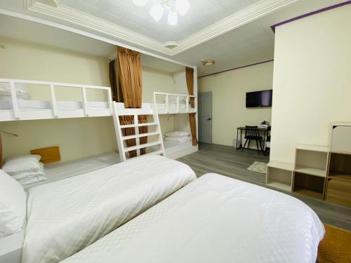 綠島鄉的住宿－好拾光民宿，一间卧室配有两张床和一张双层床。