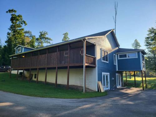 a blue house with a deck on the side of it at Hibernation Haven in McHenry