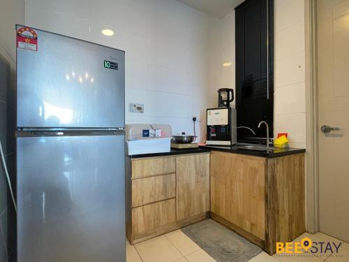 a kitchen with a stainless steel refrigerator and a counter at The Wave Suites Melaka in Melaka