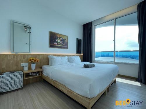a bedroom with a large bed with a large window at The Wave Suites Melaka in Melaka