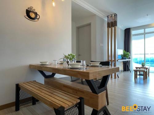 a dining room with a table and a bench at The Wave Suites Melaka in Melaka