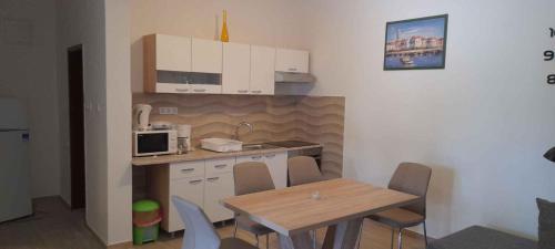 cocina con mesa, mesa y sillas en Apartment Lopar 9, en Lopar