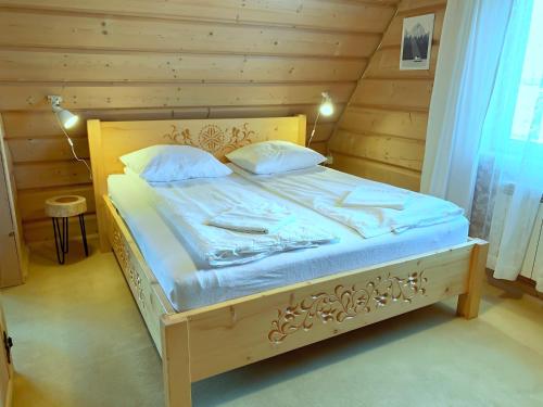 a wooden bed with blue sheets and pillows on it at Pokoje Maria Mąka in Zakopane