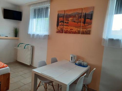 a dining room with a white table and chairs at Pension Horvath in Sankt Kanzian