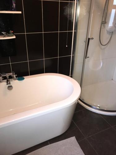 a bathroom with a white bath tub and a shower at Pat's Place in Ballaghaderreen