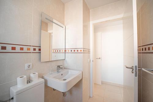 Baño blanco con lavabo y espejo en Expoholidays - Apartamento Auditorio Roquetas, en Roquetas de Mar