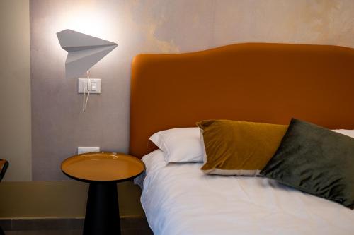 a bed with an orange headboard and a table next to it at Cielo e Nuvole in Cagli