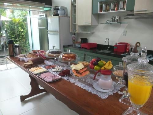 a table with a bunch of food on it in a kitchen at Pousada Ares do Sul in Penha