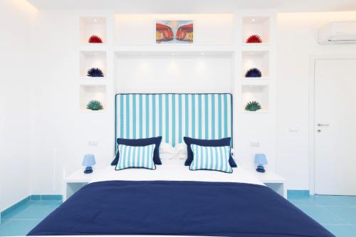 een slaapkamer met een blauw en wit bed met kussens bij Blu Oltre in Sorrento