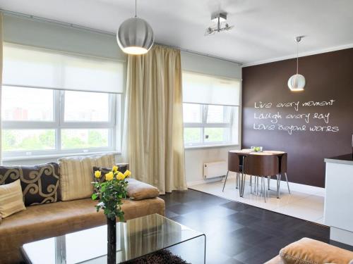 a living room with a couch and a table at Apartamenty KTW Dębowe Tarasy in Katowice