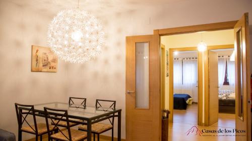 ein Esszimmer mit einem Tisch und einem Kronleuchter in der Unterkunft Apartamento El Soplao - Casas de los Picos in Celis