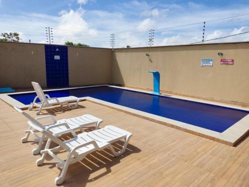 a swimming pool on top of a building with chairs at Condomínio Dunas Residence - Casa 7 e Casa 10 - Santo Amaro - MA in Santo Amaro
