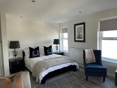 a bedroom with a bed and a blue chair at Seafront Luxury Apartment in Cleethorpes