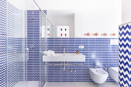 een blauwe en witte badkamer met een wastafel en een toilet bij Blu Oltre in Sorrento