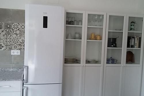 una cucina con armadietti bianchi e frigorifero di CasaPanda a Barbate