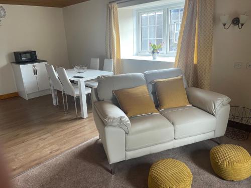 a living room with a white couch and a table at Fairladies Barn Guest House in St Bees