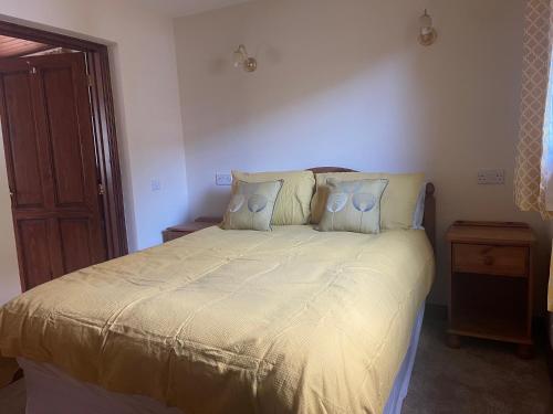 a bedroom with a large bed with two pillows at Fairladies Barn Guest House in St Bees