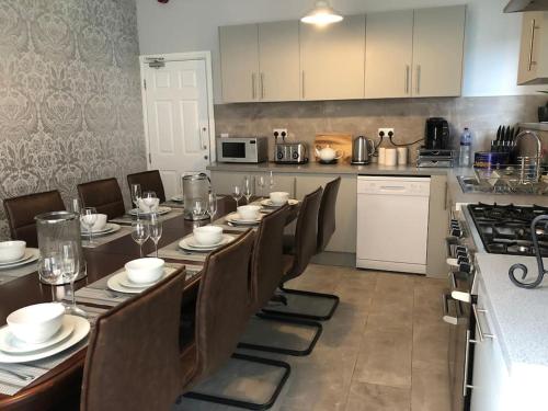 a dining room with a long table and a kitchen at Ten Streets Bed & Breakfast in Liverpool