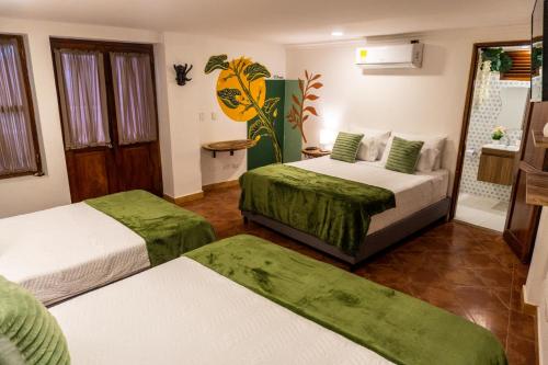 a hotel room with two beds and a bathroom at Candilejo Hotel Boutique in Cartagena de Indias