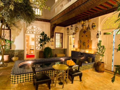 eine Lobby mit einem Tisch und Stühlen in einem Gebäude in der Unterkunft Riad La Terrasse Des Oliviers in Marrakesch