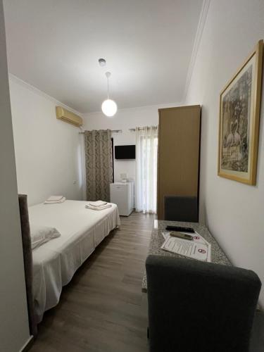 a bedroom with a bed and a desk with a laptop at Red Rose Guest House in Golem