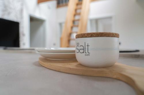 una tazza di caffè su un cucchiaio di legno su un tavolo di Neywatt 1 a Norderney